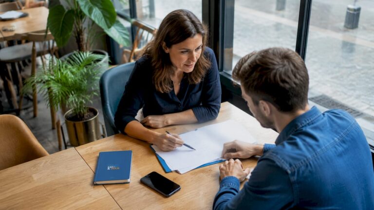 La responsable d’une PME échange avec son assistant au sujet d’un dossier important.