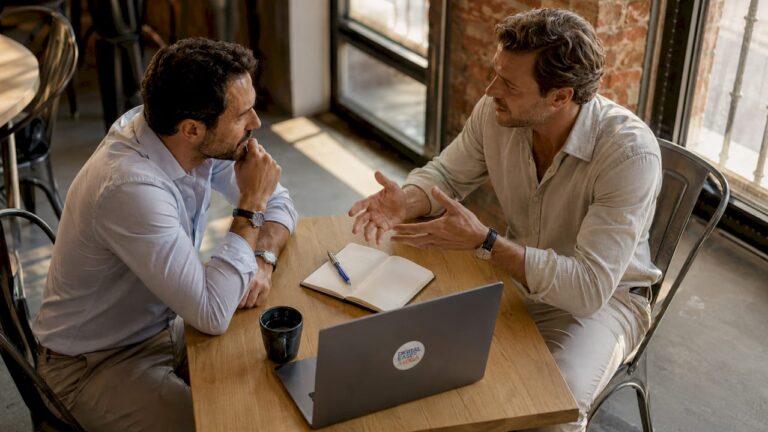 Deux chefs d’entreprise échangent autour des solutions CRM dans leur bureau.