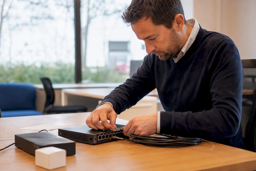 Un chef d'entreprise de PME en train de régler l'équipement réseau.