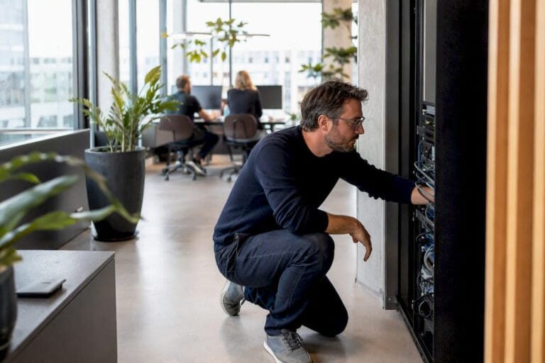 Un chef d’entreprise de PME en train de régler le matériel numérique dans son atelier