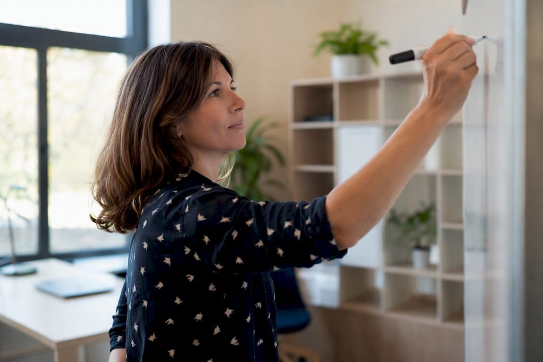 Proposition de valeur PME : la formuler et la tester vite 2 Main écrivant sur un tableau blanc dans un bureau de PME